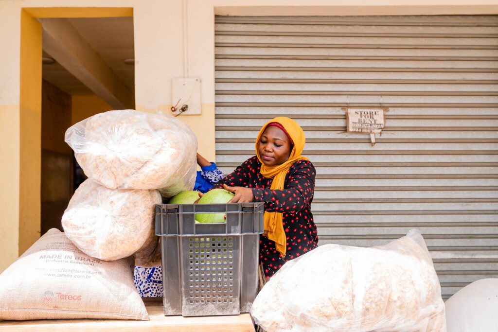 Abubakari Barikisu, a teacher at the Ahlus Sunnah Wal Jama’ah Center, one of the schools supported by Food For all Africa, receives donated cereals, watermelon and other dry foods. (Photo: The Global FoodBanking Network/Julius Ogundiran)