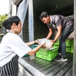 A cook and warehouse staff from Scholars of Sustenance Thailand load a truck with meals to be distributed to people experiencing hunger. (Photo: Scholars of Sustenance Thailand)
